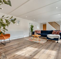 A living room with a sofa, chair, and coffee table at The Farmhouse (Pet) Perranporth