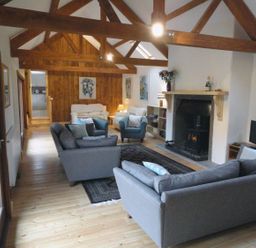 A living room with sofas and a fireplace at Nethercote Byre Minehead