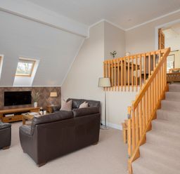 A living room with seating area and staircase at The Derwent (Pet) in Slaley