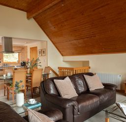 A living room with a sofa and dining area at The Hexham in Slaley