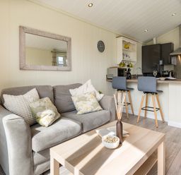 A living room with a sofa and kitchen counter at Stokesley (Pet) in Great Ayton