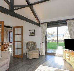 A living room with an armchair and sliding door at Long Linney in Bideford