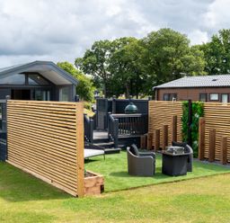 An outdoor area with a house, deck, chairs, and table at The Oasis in Great Ayton