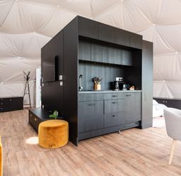 A living room with kitchen area and seating at The Dome (Pet) Great Ayton