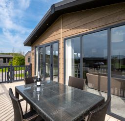 A dining table with chairs on a deck at Greystone in Great Ayton