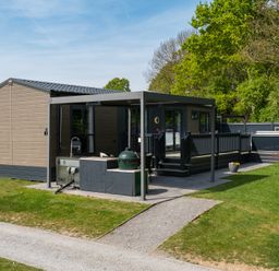 An outdoor view of a cabin with a deck and grill at The Woods in Great Ayton
