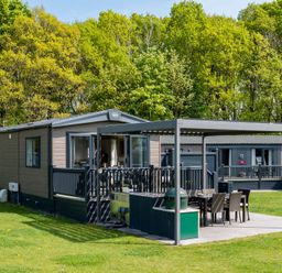 A mobile home with a deck and outdoor seating at Leven (Pet) Great Ayton