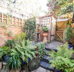 A garden with plants and a garden gate at Flat 4 in Evesham