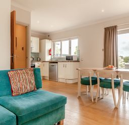 A kitchen with a sofa and dining table at 4C2 Summerleaze Garden Cottage 2 Spa in Bude