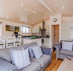 A living room with a kitchen area and seating at Hurricane Lodge in Fair Oak