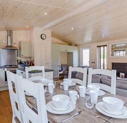 An open plan living area with dining table and kitchen at Hurricane Lodge in Fair Oak