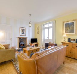 A living room with sofas and a fireplace at The Old Signal House in Torpoint
