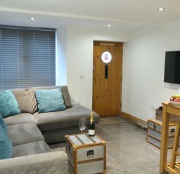 A living room with a sofa and table at Rockfish Cottage in Brixham