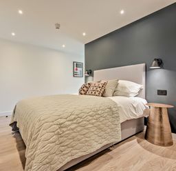 A bedroom with a bed and bedside table at Arvor Suite 1.0 in Marhamchurch