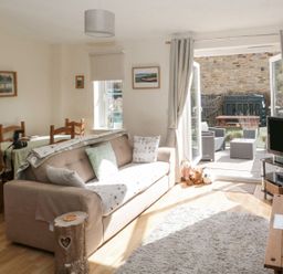 A living room with a sofa and television at Ramblers Cottage in Alnwick