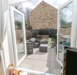 A garden patio with furniture and planters at Ramblers Cottage in Alnwick