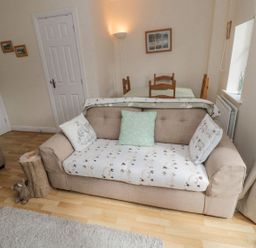 A living room with a sofa and dining table at Ramblers Cottage in Alnwick