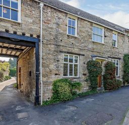An outdoor view of a stone building with windows and plants at Ostlers Burford