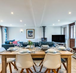 A dining room with a table set for dinner at Woodyplatt in Marhamchurch