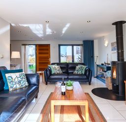 A living room with sofas and a fireplace at Chapel Park in Marhamchurch