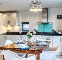 A kitchen with a dining table and chairs at Chapel Park in Marhamchurch