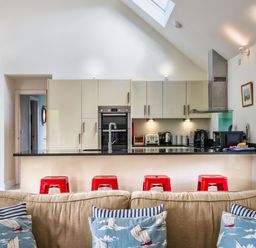 A kitchen with cabinets and appliances at Little Main in Marhamchurch