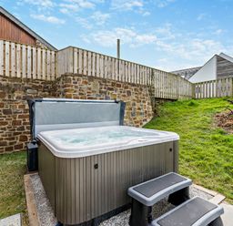 A hot tub with steps in an outdoor area at Long Down Spa in Marhamchurch