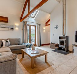 A living room with a sofa and coffee table at Long Down Spa in Marhamchurch