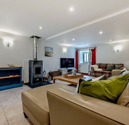 A living room with a stove and sofa at Middle Hill in Marhamchurch