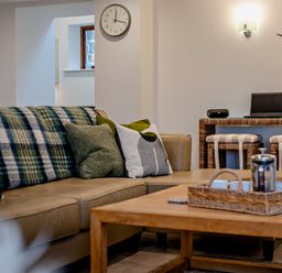 A living room with a sofa and table at Middle Hill in Marhamchurch