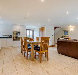 A dining room with a table and chairs at Sand Parks in Marhamchurch