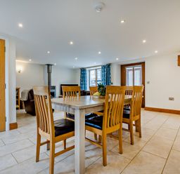 A dining room with a table and chairs at Sand Parks in Marhamchurch