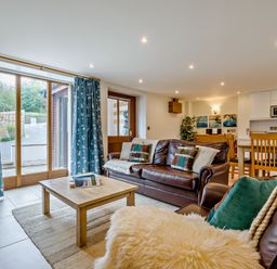 A living room with a sofa and coffee table at Sand Parks in Marhamchurch
