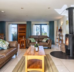 A living room with a fireplace and seating at Venners in Marhamchurch