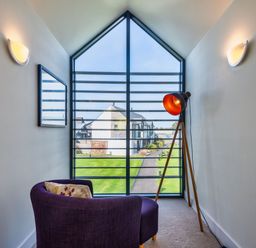 A seating area with a lamp and mirror at Venners in Marhamchurch