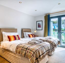 A bedroom with two beds and a window at Venners in Marhamchurch