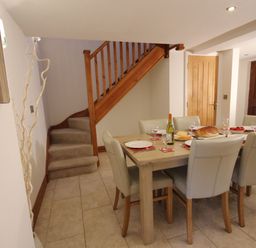 A dining room with a table set for a meal at Westcotts in Marhamchurch