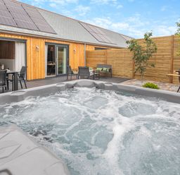 A hot tub in an outdoor space at Gwari Spa Barn 2.0 Marhamchurch
