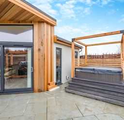 An outdoor area featuring a hot tub and a wooden frame at Trelowen 2.0 Spa Marhamchurch