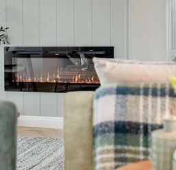 A living room with a fireplace and a plant at Trelowen 2.0 Spa Marhamchurch