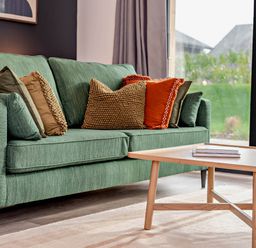 A couch with throw pillows and a coffee table in a living room at Arvor Duplex 2.0 Marhamchurch