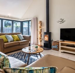 A living room with a sofa, coffee table, and fireplace at Nettlecoombe Spa in Marhamchurch
