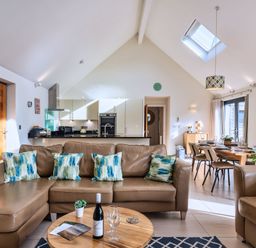 A living room with a sofa and dining area at Nettlecoombe Spa in Marhamchurch