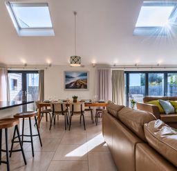 A living room with a sofa and dining table at Nettlecoombe Spa in Marhamchurch