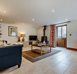 A living room with a sofa, coffee table, and television at Jack's House in Marhamchurch