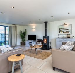 A living room with a fireplace and television at Arundell in Marhamchurch