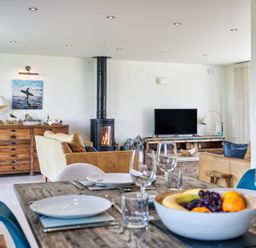 A living room with a fireplace and seating area at Eagle's Nest in Marhamchurch