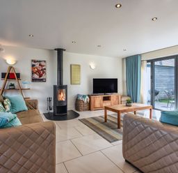 A living room with a fireplace and television at Sheep's House in Marhamchurch