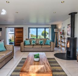 A living room with a fireplace and sofas at Sheep's House in Marhamchurch