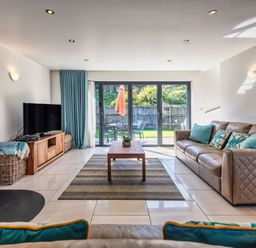 A living room with a sofa, coffee table and television at Sheep's House in Marhamchurch